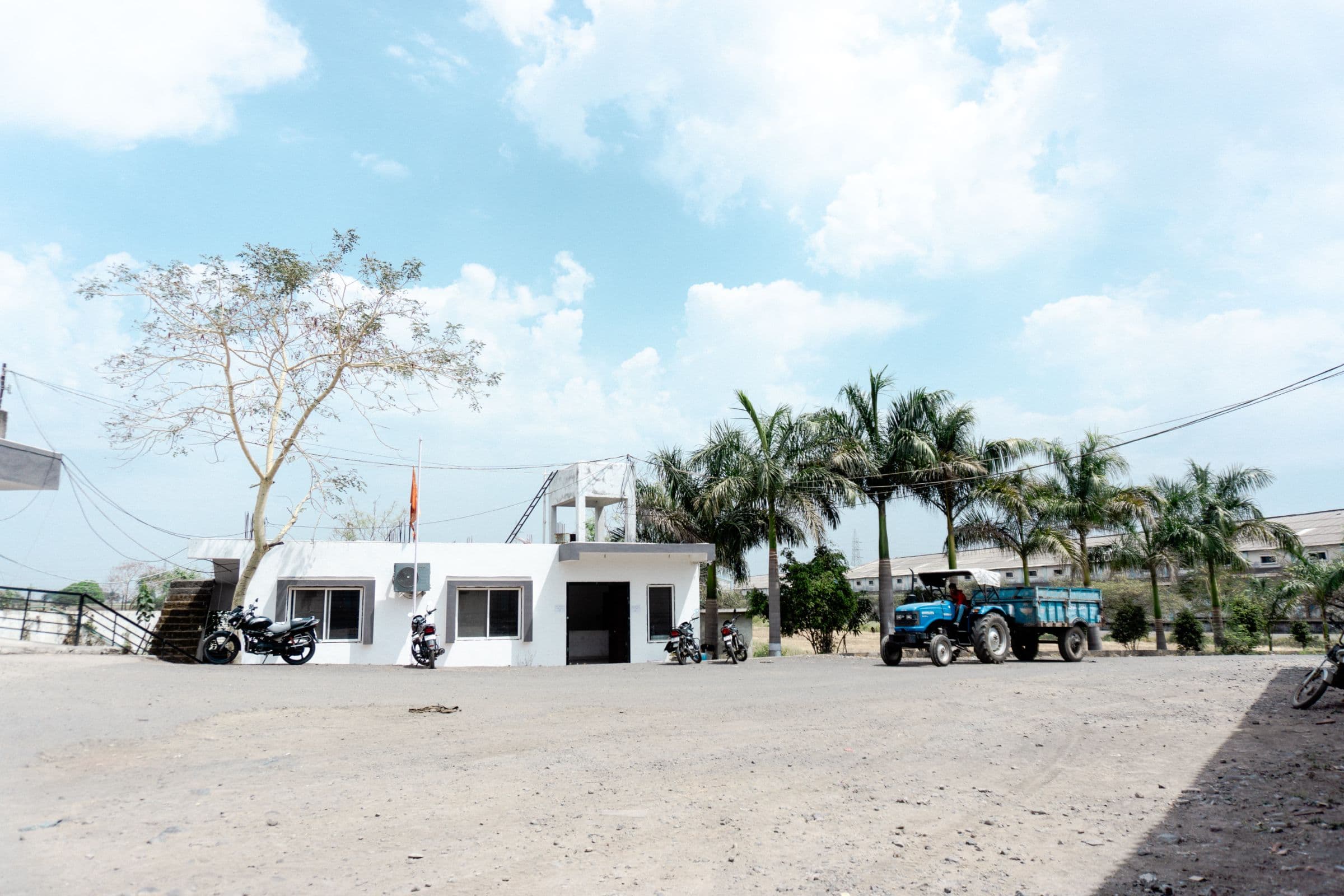 The yard inside the gate, with a single-storey building and a row of palm trees